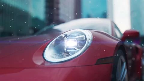 Red car close-up shining headlights in an urban environment with a rain and s Stock Footage 232204047