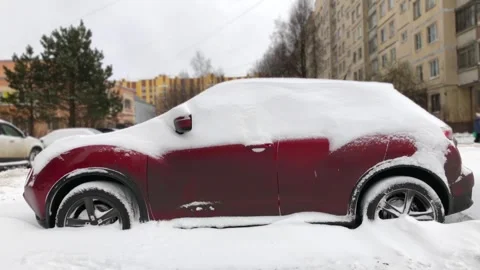 Red car covered with a thick layer of snow Stock Footage 259518780