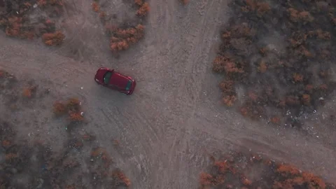 Red Car on Desert Dirt Track, Top-Down Drone at Dusk Stock Footage 323915538
