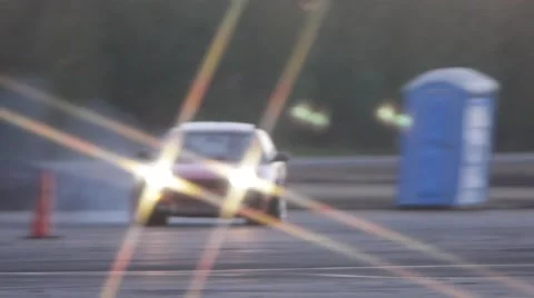 Red car drifts around corner on race track at drifting event at dusk. Stock Footage 59762285