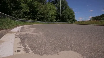 Red car driving along steep road turn on highway road Video stock 85830359