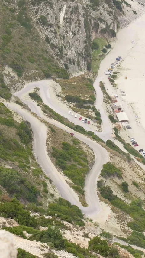 Red car driving down winding mountain road Stock Footage 294963906