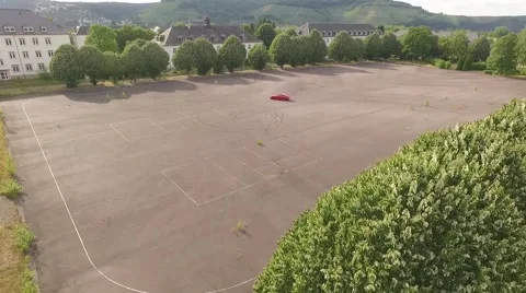Red car driving on empty square Stock Footage 53223108