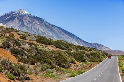 Red car driving on open highway near Teide volcano mountain summit, Tenerife Stock Photos