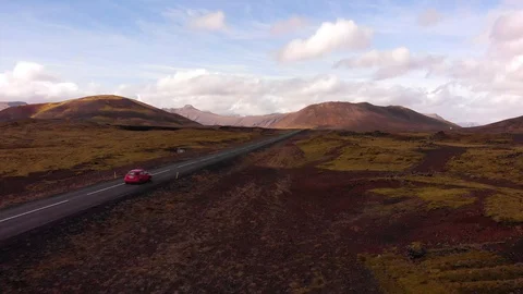 Red car driving on the Ring Road in Iceland in spring. Adventure travel. Stock Footage 129841907