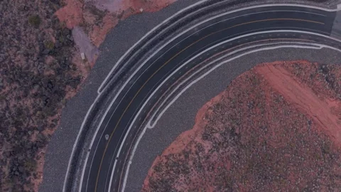 Red car driving on winding desert road in St George, Utah, USA Stock Footage 333923499