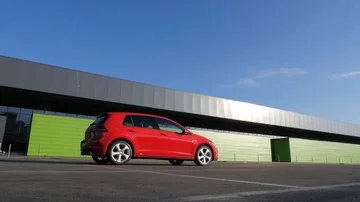 Red car hatchback standing at parking place on backgroung green building Stock Footage 85830420