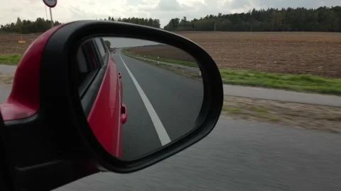 Red car in motion, the road is reflected in the long-distance mirror of the car Stock Footage 142525039