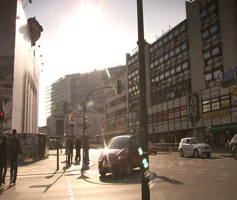 Red car moves through intersection, a few pedestrians cross street Stock Footage 86742942