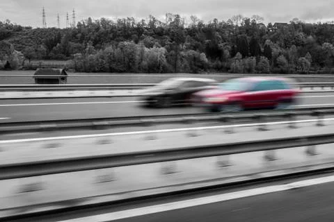 Red car overtaking, selective colour in B&amp;W image Fotos Stock