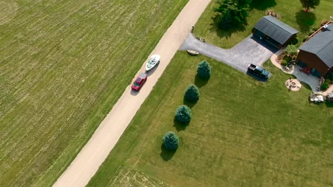 Red Car Pulling a Boat next to a Farm on a Country Road Stock Footage 145239638