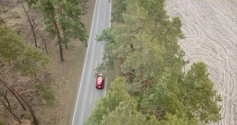 Red car ride by the forest road. Top view aerial shot 4k Stock Footage 128148507