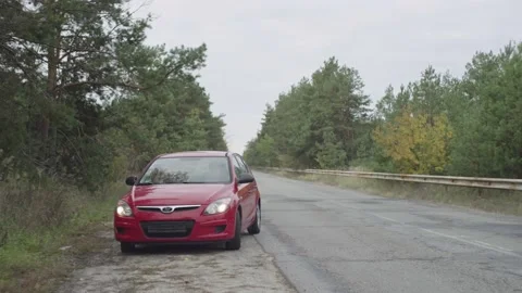 The red car stops on the side of the road due to a malfunction, a flat tire Stock Footage 237284709