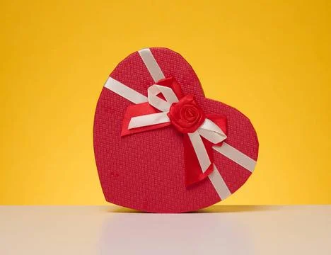 Red cardboard gift box in the shape of a heart on a yellow background Red ... Stock Photos