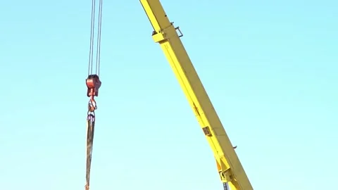 Red cargo hook of a crane with cargo transport slings hanging from an Stock Footage 154727556