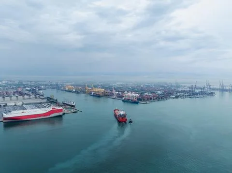 Red Cargo Ship Navigating Busy Industrial Harbor At Laem Chabang Port High .. 库存照片