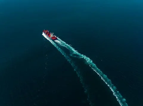 Red Cargo Ship Navigating Through Calm Blue Ocean Waters Wide Angle Shot Stock Photos
