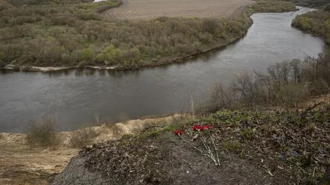 Red carnations left at the edge of Krivoborye cliff by the winding Don River Stock Photos