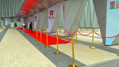 Red carpet setup outside a building in Belarus with two people preparing for an Stock Footage 337525348