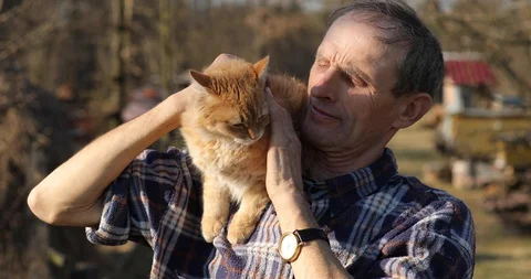 Red cat on the shoulder of an older man. cat sits on the shoulders of an old man Stock Footage 127942601
