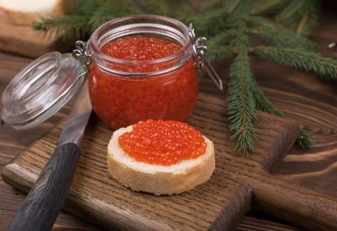 Red caviar on a bread with a Christmas tree. The main dish of the New year Stock Photos