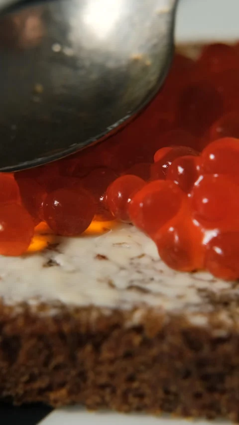 Red caviar on buttered rye bread slice 스톡 동영상 322220375