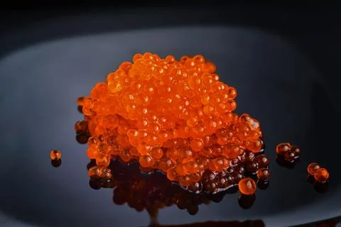 Red caviar on a dark background with reflection Stock Photos