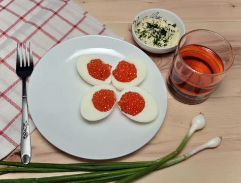 Red caviar with egg on a white plate. Stock Photos