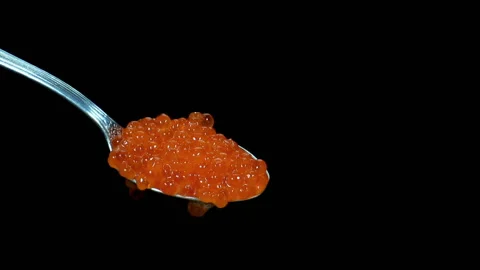Red caviar falls from a spoon Stock Footage 138980223