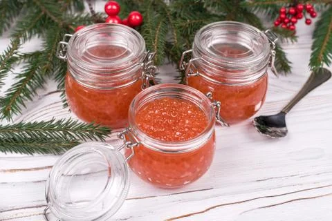 Red caviar in jar on aged white wooden background. Main dish New Year Stock Photos