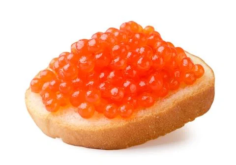Red caviar on a piece of bread close-up on a white. Isolated Stock Photos