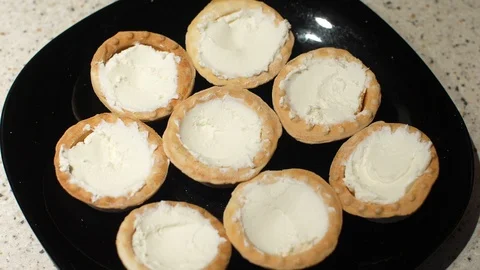 Red caviar is put with a spoon on tartlets with cottage cheese. Preparation of Stock Footage 119403704