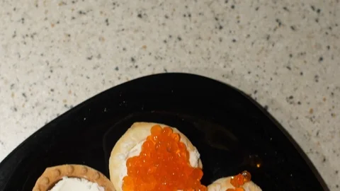 Red caviar is put with a spoon on tartlets with cottage cheese. Preparation of Stock Footage 119403784