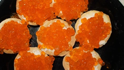 Red caviar is put with a spoon on tartlets with cottage cheese. Preparation of Stock Footage 119403848
