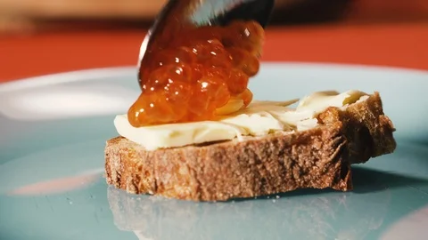 Red caviar. Red caviar spread on brown bread and butter. Video stock 122413985