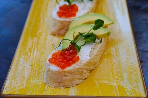 Red caviar Rye bread slice with smoked salmon and avocado isolated on white Foto stock