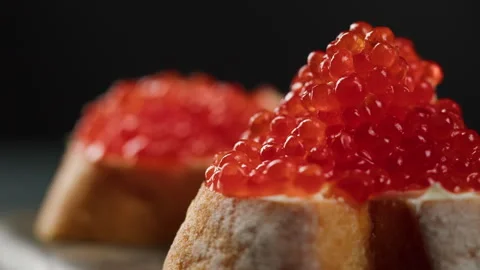 Red caviar sandwiches close-up. Bread with salmon salted orange roe on black Stock Footage 166470231
