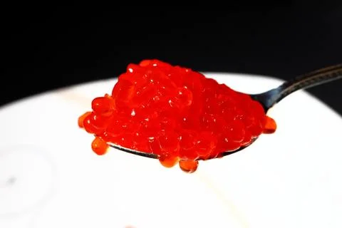 Red caviar in the silver spoon. Macro. Stock Photos