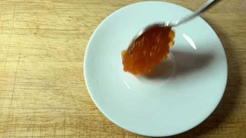 Red caviar with a spoon is placed on a plate in 4K Stock Footage 132734859