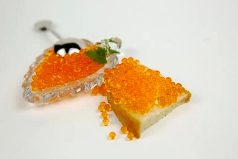 Red caviar spreading bread on a white background Stock Photos