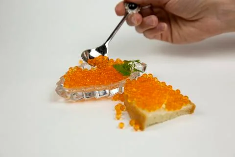 Red caviar spreading bread on a white background Stock Photos