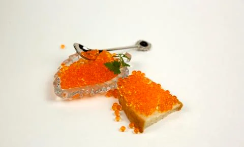 Red caviar spreading bread on a white background Stock Photos
