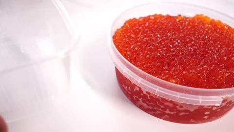 Red caviar type spoon. Plastic container with salted caviar of salmon fish on Stock-Footage 119254317