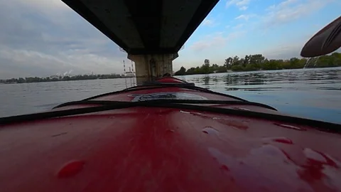 Red cayak or canoe floating under the bridge in city river. Dnipro in Kyiv Stock Footage 117113345