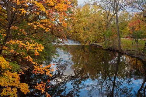 Red Cedar river winding through Michigan State University campus during the Fall Stock Photos