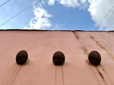 Red cement wall with three ventilation holes Фото