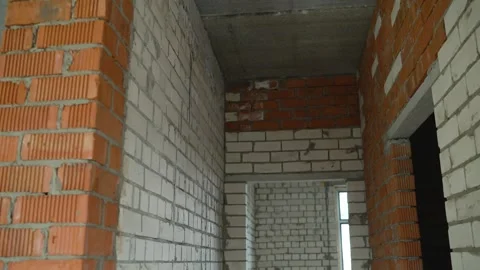 Red ceramic brick column and white silicate brick walls inside unfinished house Stock Footage 344906140