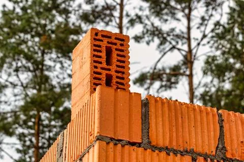 Red ceramic bricks at the construction site. Keramoblock. Hollow brick. Const Stock Photos