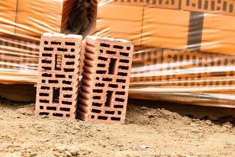 Red ceramic bricks at the construction site. Keramoblock. Hollow brick. Const Stockfoto's