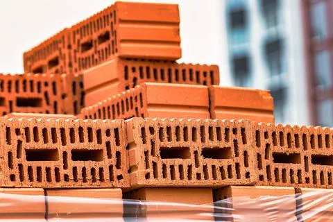 Red ceramic bricks at the construction site. Keramoblock. Hollow brick. Const Stockfoto's